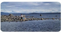 Breakwater, ocean, rocks, and mountains